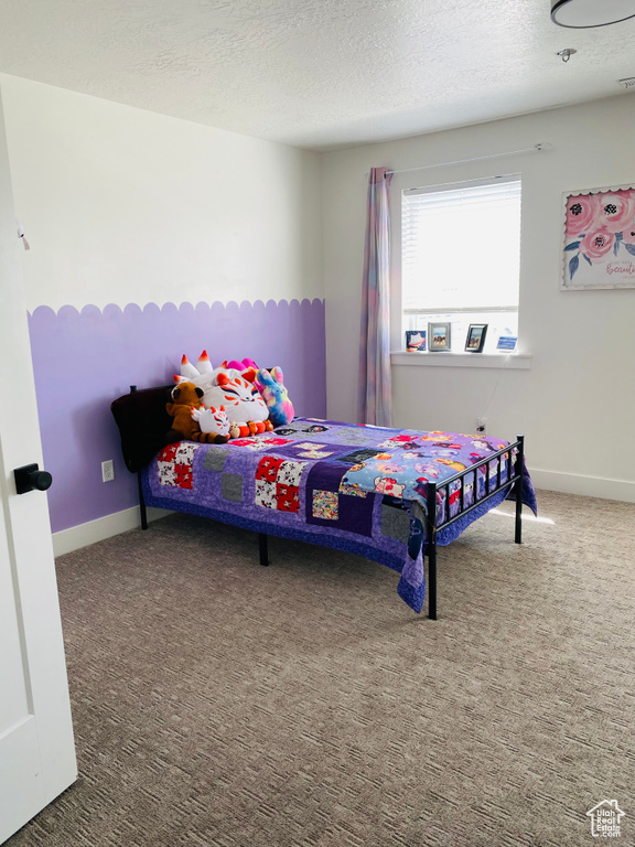 Bedroom featuring a textured ceiling, baseboards, and carpet floors
