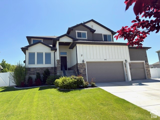 Craftsman-style home with stone siding, driveway, a gate, an attached garage, and board and batten siding