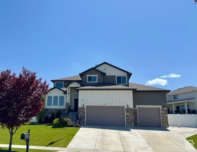 View of front of property with stone siding, concrete driveway, and an attached garage