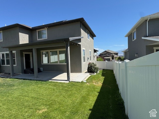 Back of property featuring a fenced backyard, a patio area, and stucco siding