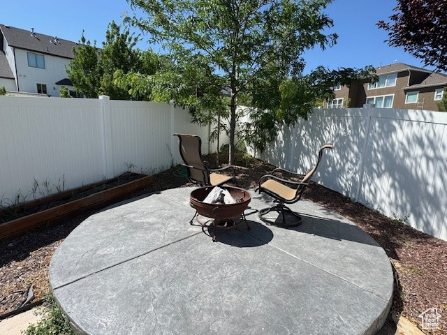 Fenced backyard with a fire pit and a patio