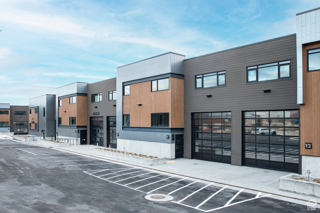 View of building exterior featuring uncovered parking