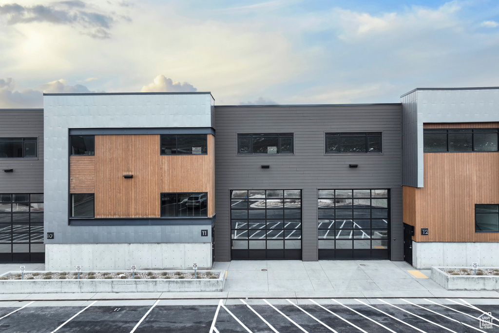 View of building exterior featuring uncovered parking