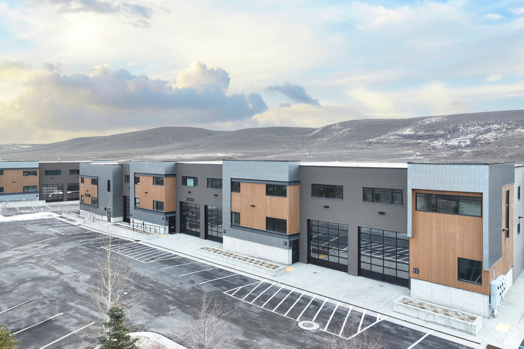 View of property with uncovered parking and a mountain view