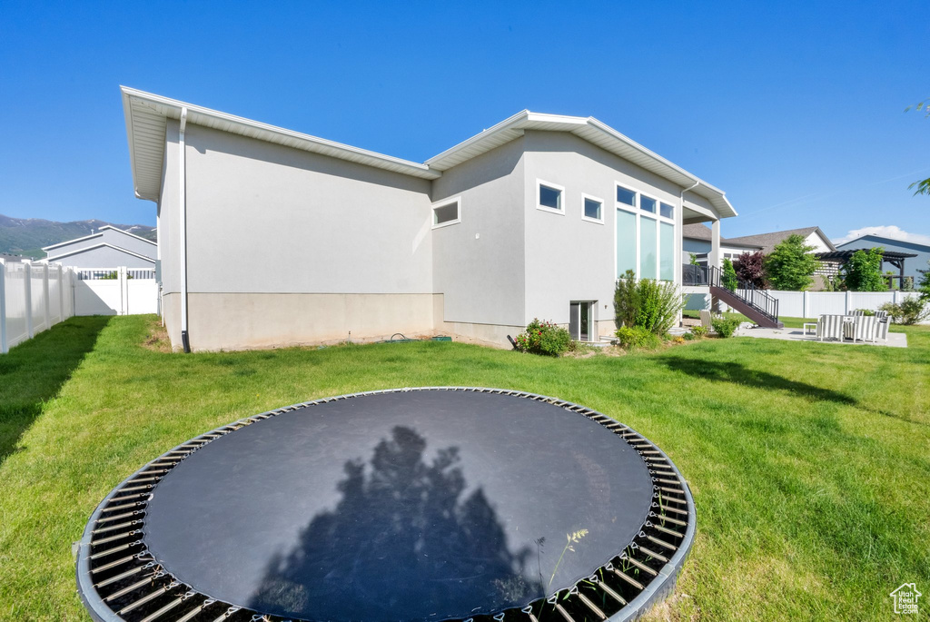 Fenced backyard with a trampoline and stairway