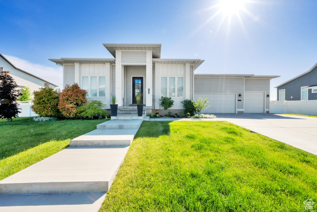 View of front facade with an attached garage, concrete driveway, and board and batten siding
