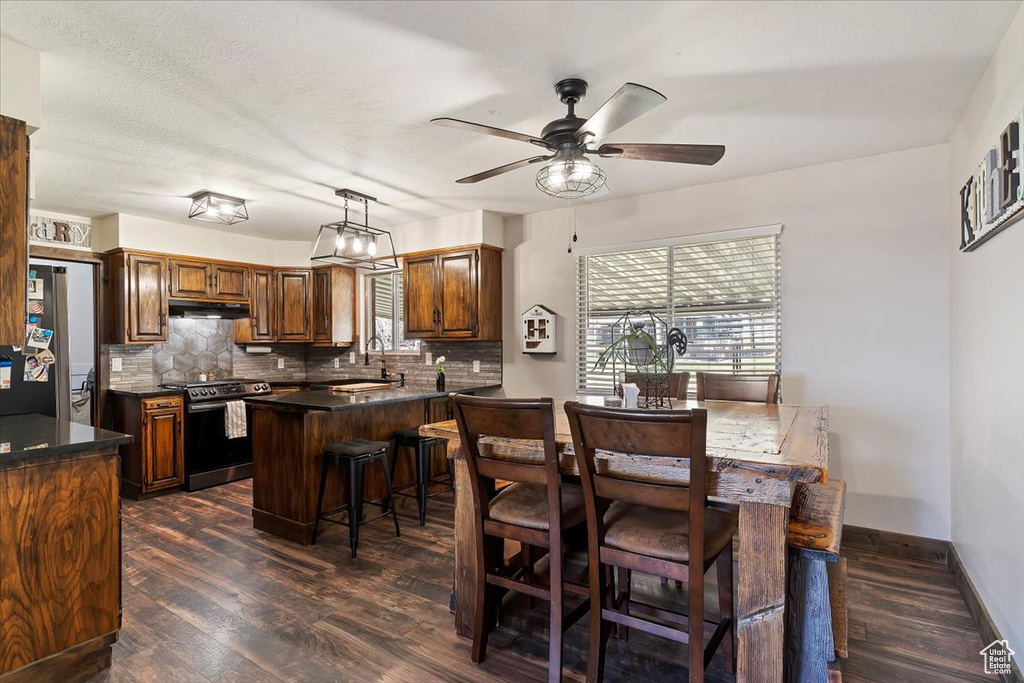 Dining space featuring dark wood-style floors, baseboards, and a ceiling fan