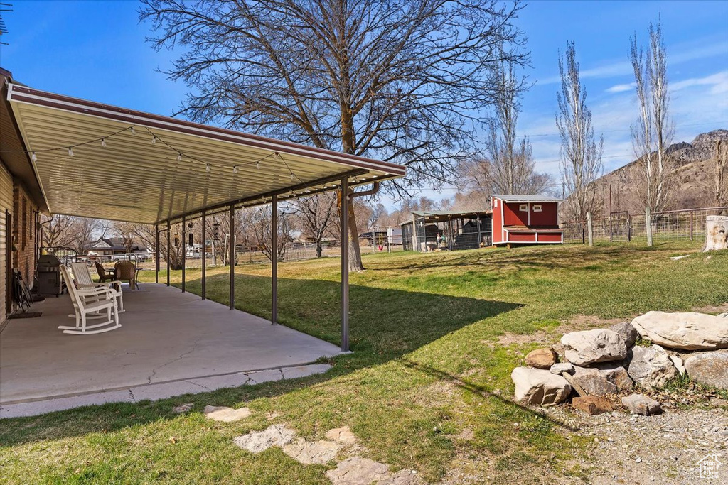 View of yard with fence and a patio