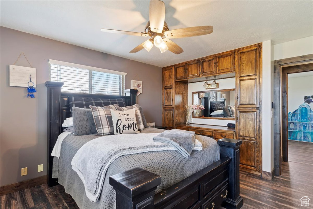 Bedroom featuring baseboards, dark wood-style floors, and a ceiling fan