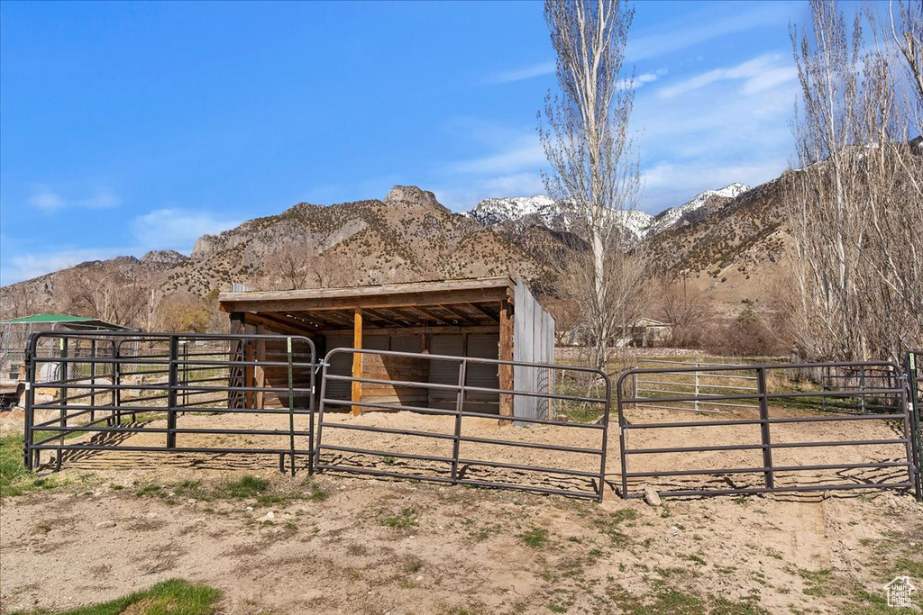 View of horse barn with a rural view and a mountain view