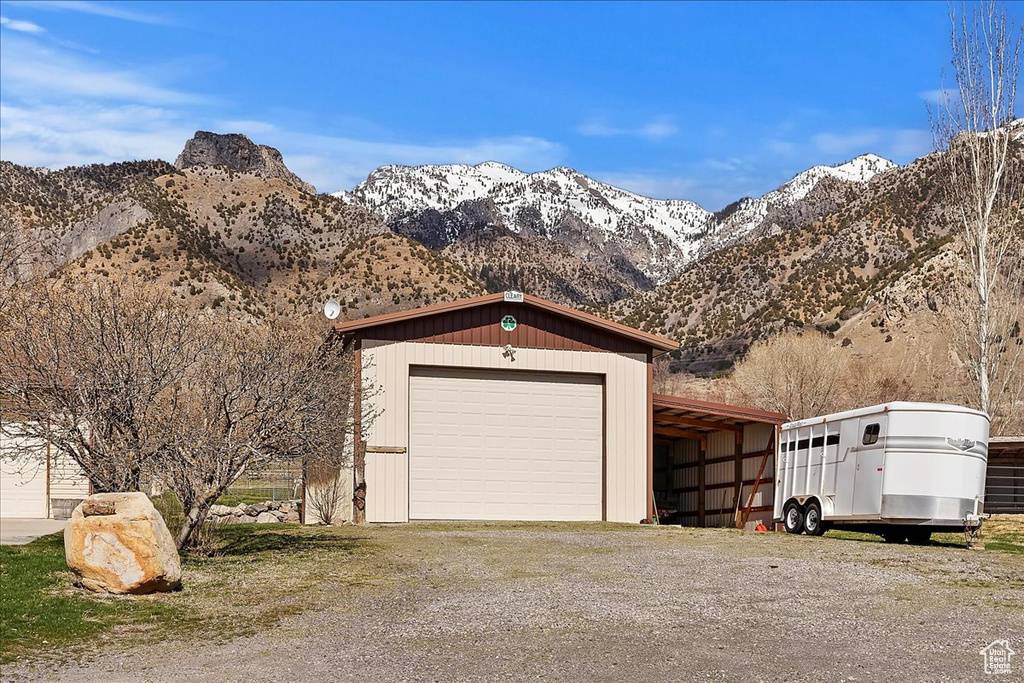 Garage with dirt driveway, a mountain view, and a garage