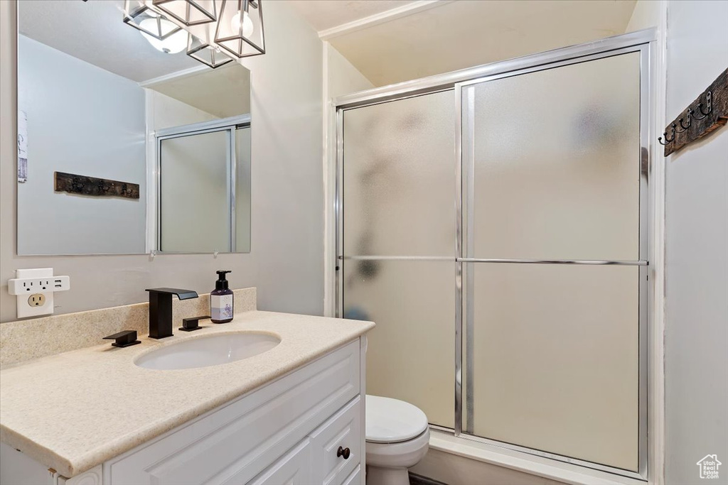 Bathroom with an enclosed shower, toilet, and vanity