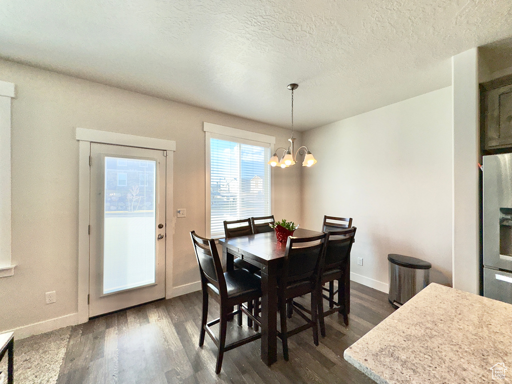 Dining area featuring baseboards, a chandelier, and dark wood finished floors