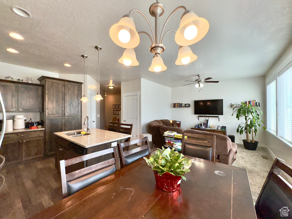 Dining room with a textured ceiling, dark wood-style flooring, ceiling fan, and baseboards