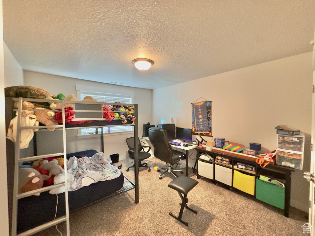 Bedroom with carpet floors and a textured ceiling