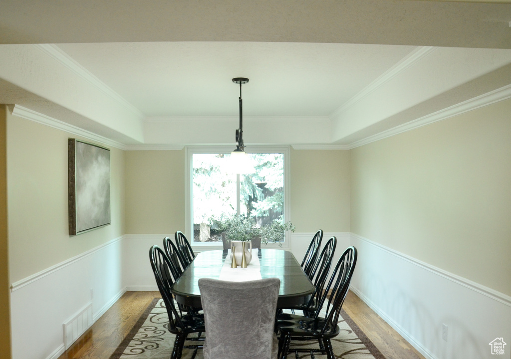Dining space featuring visible vents, ornamental molding, and wood finished floors
