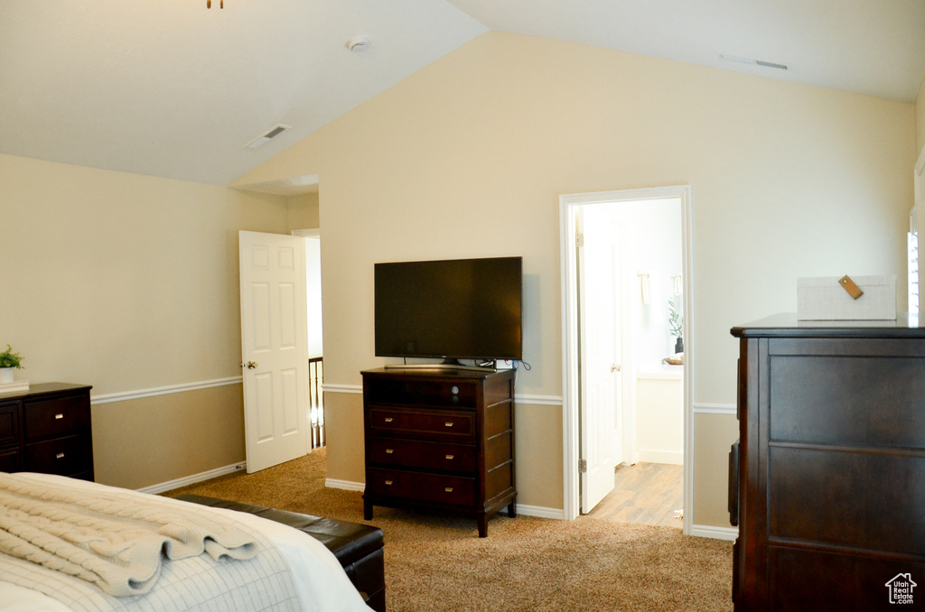 Bedroom featuring baseboards, carpet flooring, visible vents, and vaulted ceiling