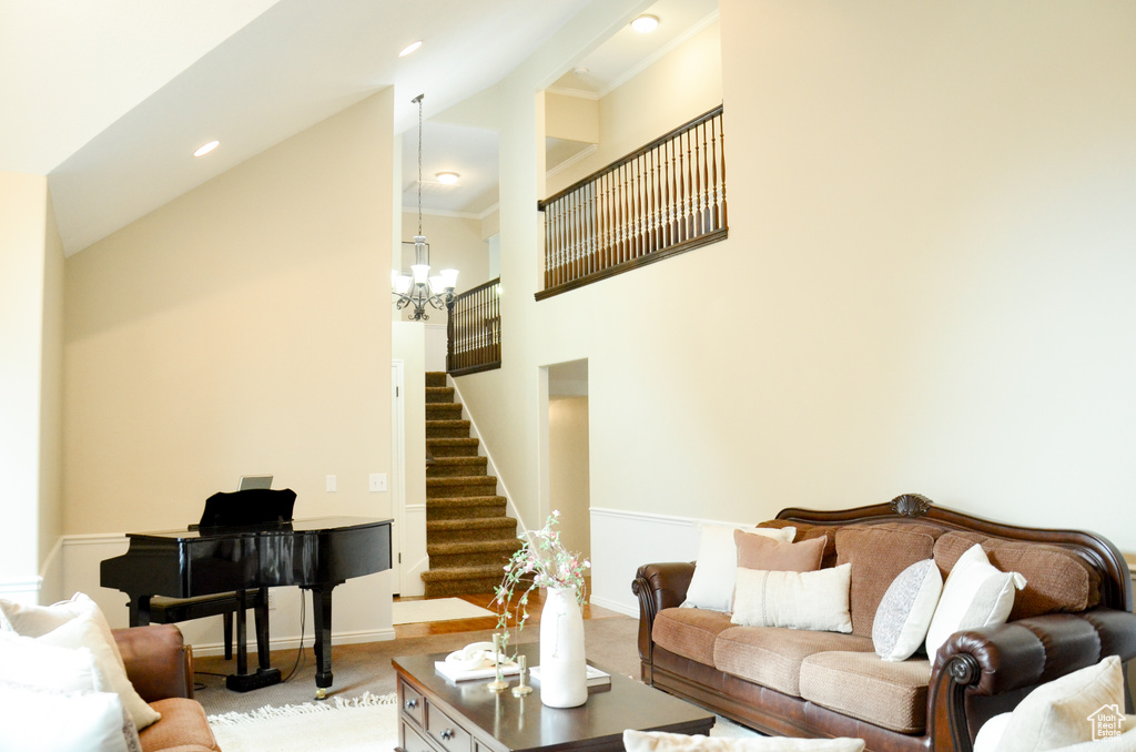 Living room with baseboards, a high ceiling, a chandelier, stairs, and carpet flooring