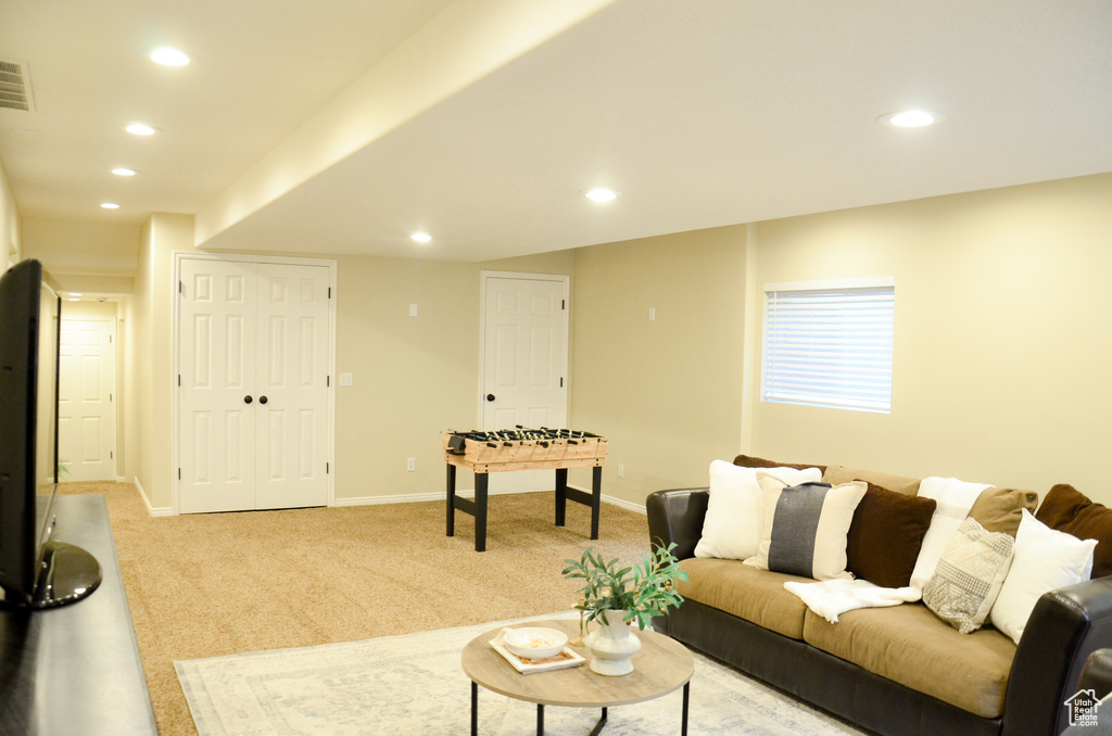 Living area featuring baseboards, recessed lighting, and light colored carpet
