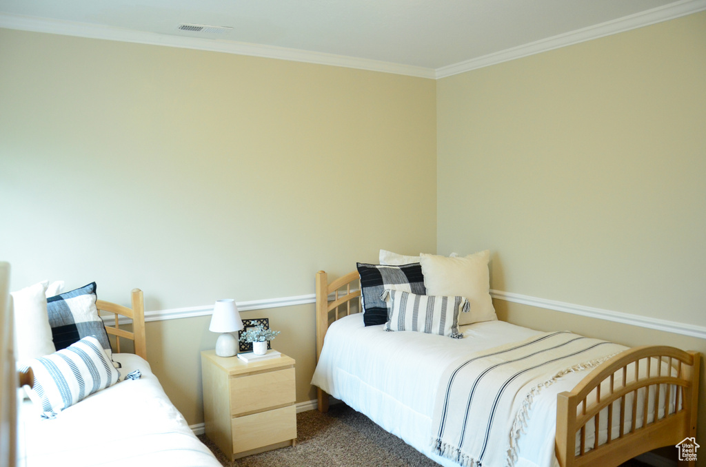 Bedroom with visible vents, carpet, and crown molding