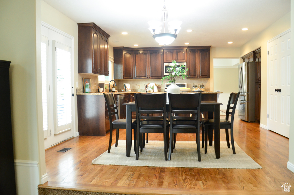 Kitchen featuring light countertops, dark brown cabinetry, light wood-style floors, and stainless steel appliances