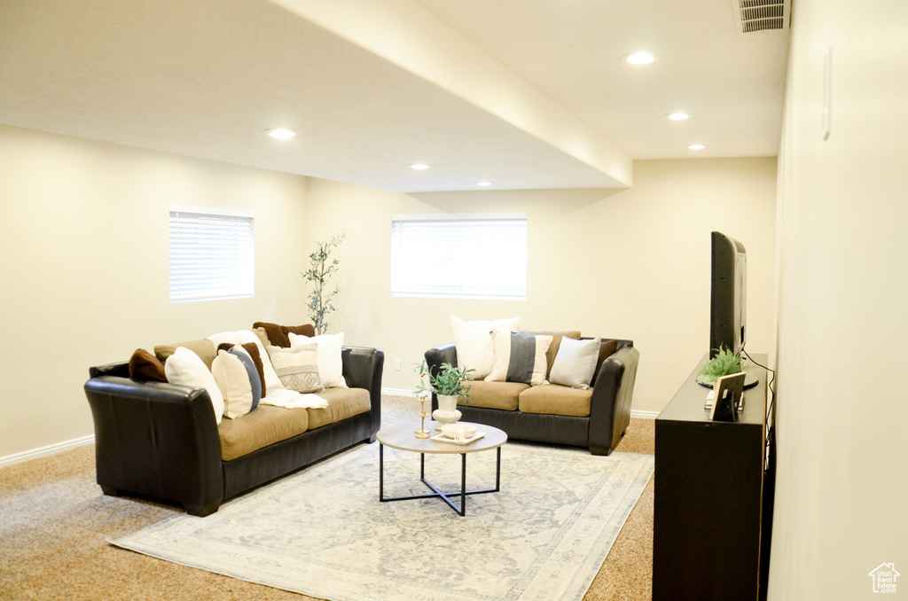 Carpeted living area with baseboards, visible vents, and recessed lighting