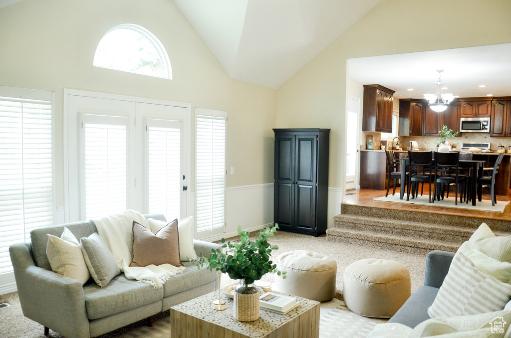 Living room with a chandelier, recessed lighting, and high vaulted ceiling