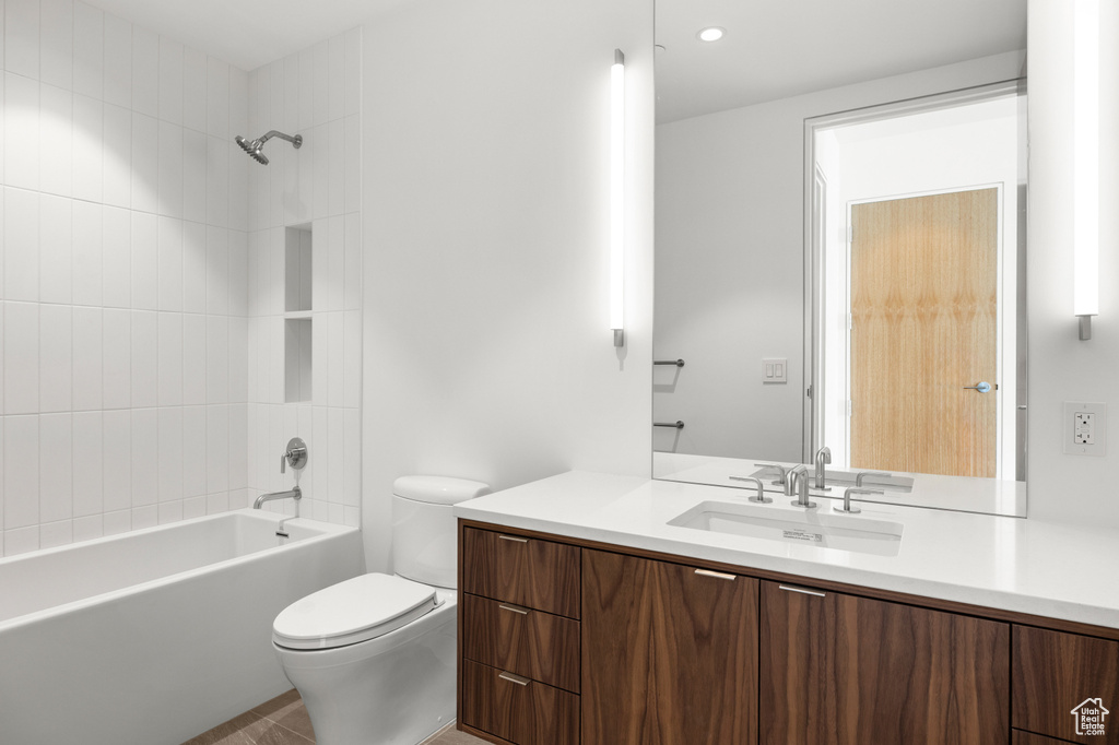 Full bathroom featuring toilet, vanity, and shower / washtub combination