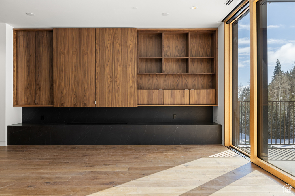 Interior space with wood finished floors, a wall of windows, and plenty of natural light