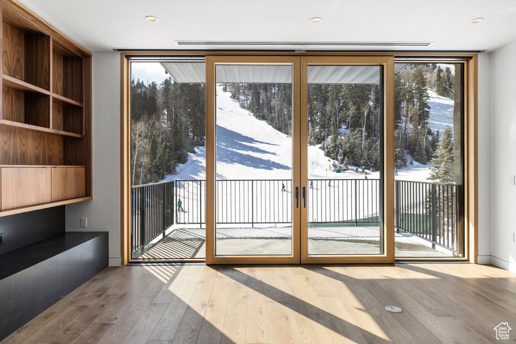 Doorway with plenty of natural light, a wall of windows, and hardwood / wood-style flooring