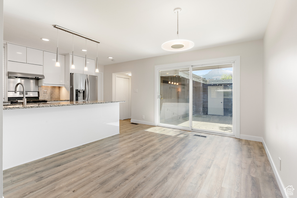 Interior space featuring a sink, baseboards, recessed lighting, and light wood-type flooring