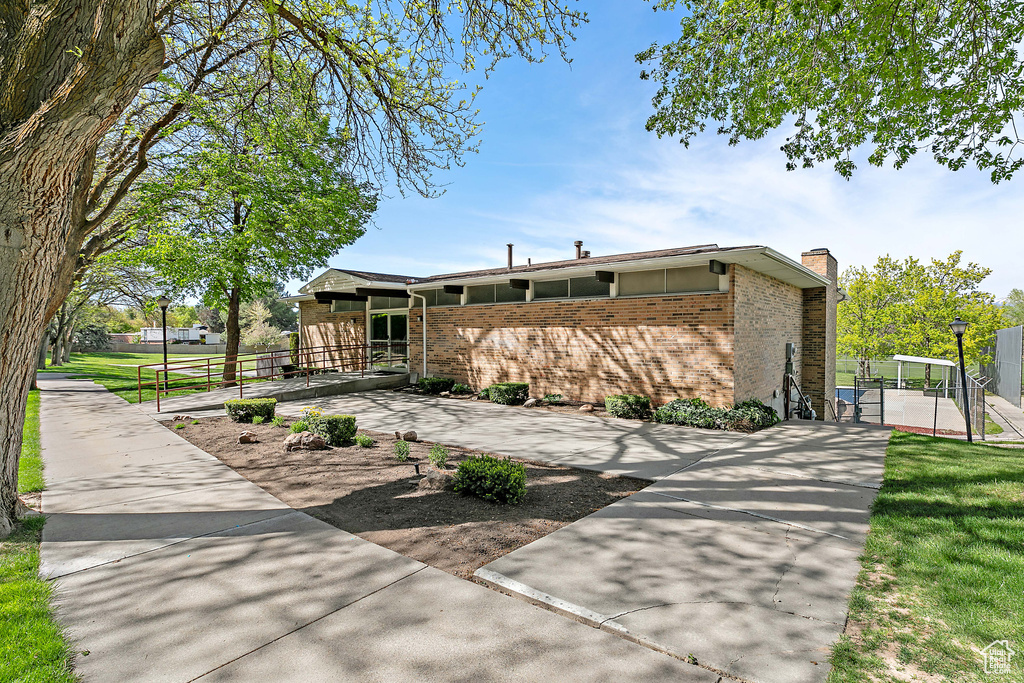 View of home\'s exterior featuring fence, a gate, a chimney, and brick siding