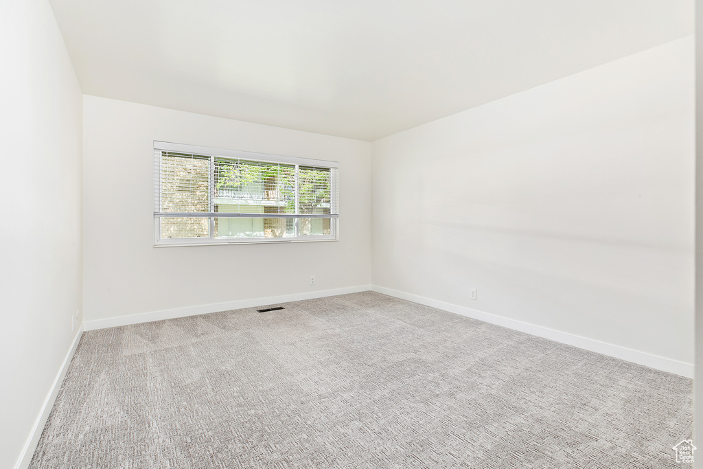 Carpeted spare room with baseboards and visible vents