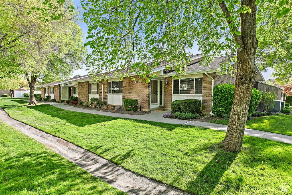 Ranch-style house featuring central air condition unit, a front lawn, and brick siding