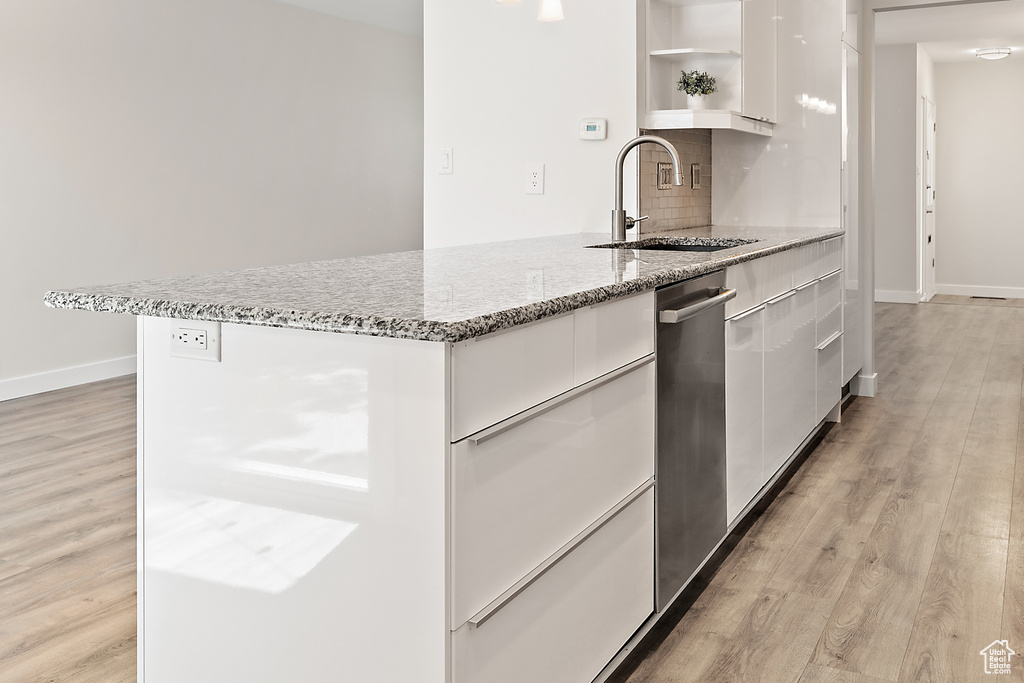 Kitchen with backsplash, modern cabinets, open shelves, a sink, and white cabinets