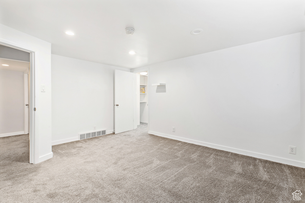 Empty room with visible vents, recessed lighting, carpet, and baseboards