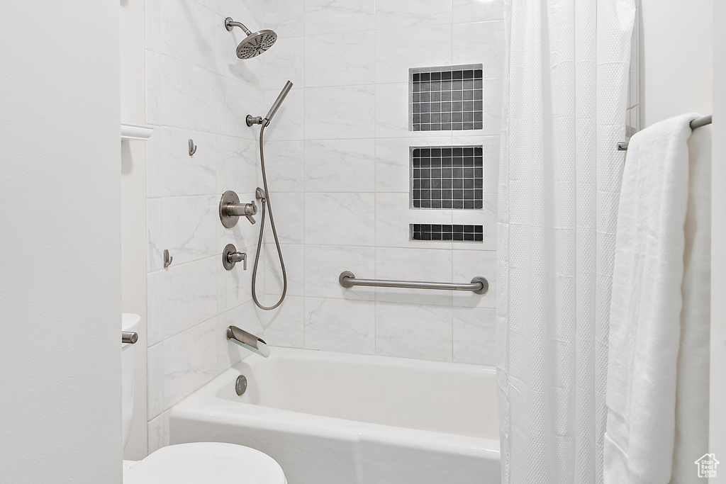 Bathroom featuring shower / bath combo with shower curtain and toilet