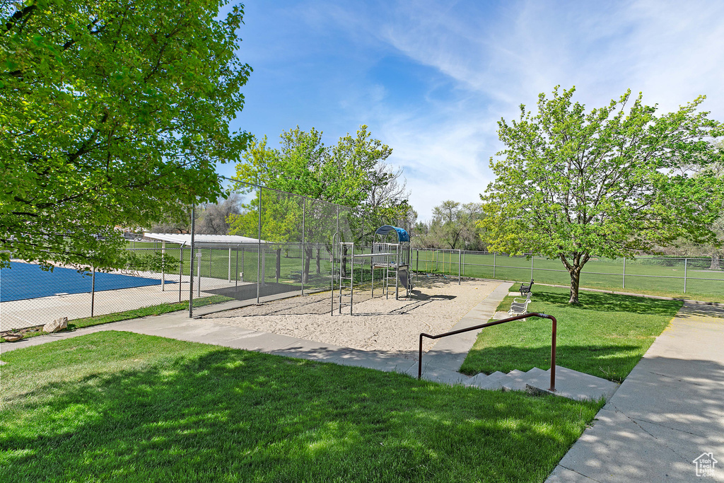Community jungle gym with fence and a lawn