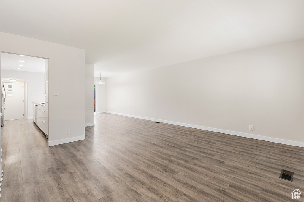 Empty room featuring baseboards, visible vents, and wood finished floors