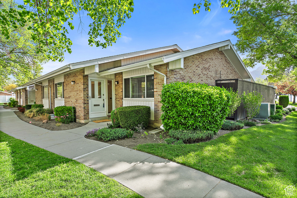 View of front facade with a front lawn and brick siding