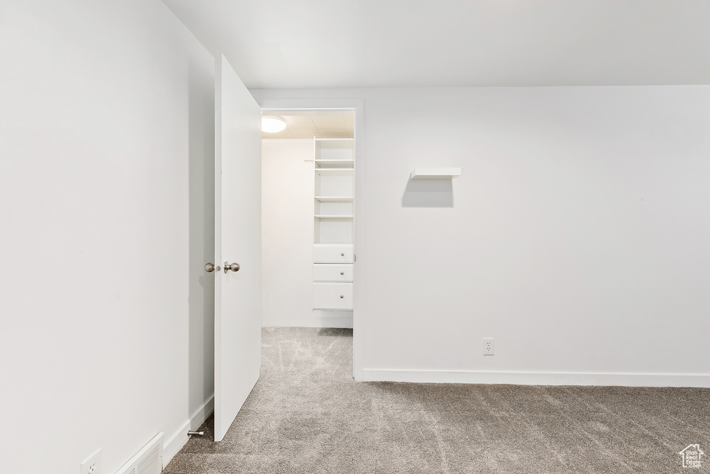 Unfurnished bedroom with carpet floors, a closet, and a walk in closet