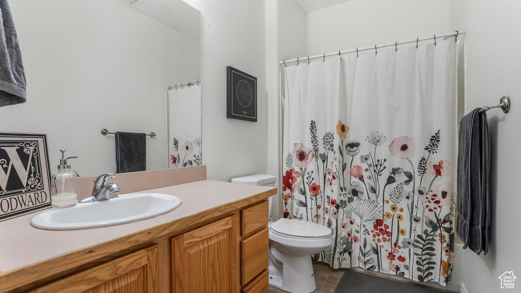 Full bathroom featuring toilet, tile patterned flooring, vanity, and a shower with shower curtain