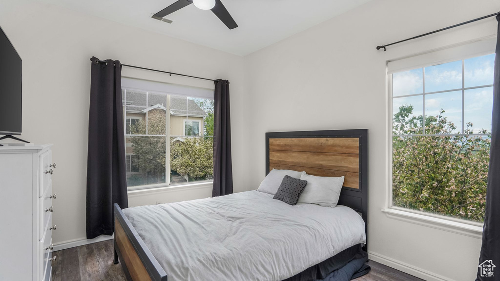 Bedroom featuring dark wood-type flooring, baseboards, and ceiling fan