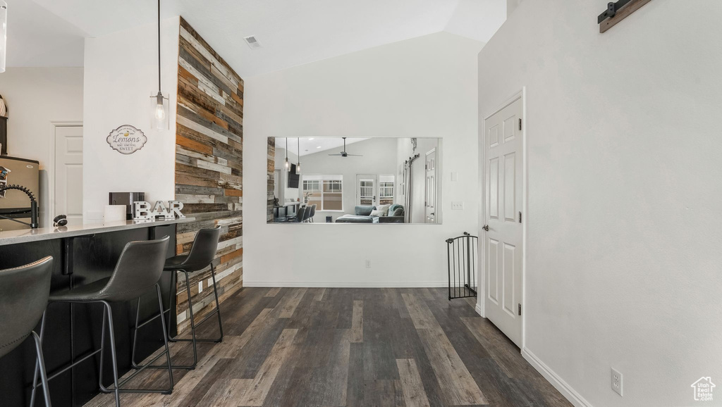 Corridor with dark wood finished floors and high vaulted ceiling