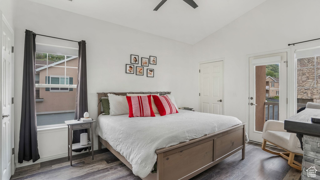 Bedroom with vaulted ceiling, wood finished floors, access to exterior, and ceiling fan