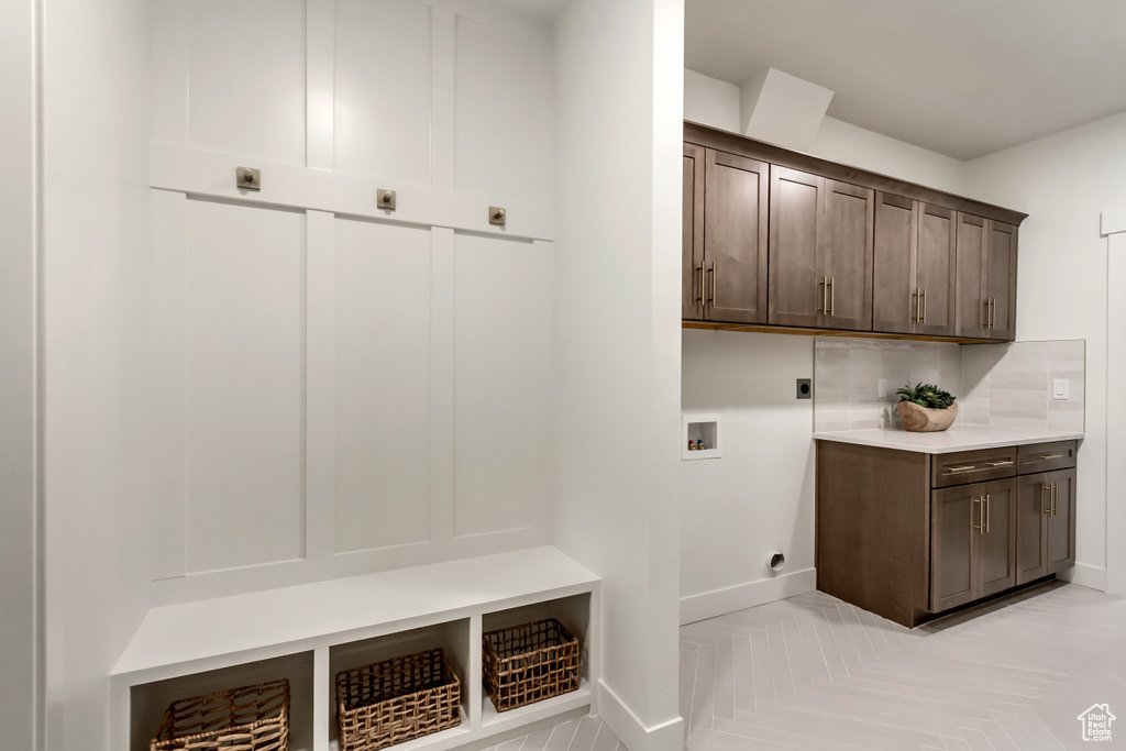 Laundry room featuring hookup for a washing machine, cabinet space, hookup for an electric dryer, and baseboards