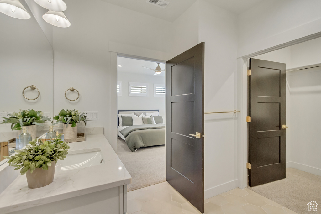 Bathroom featuring ensuite bath, ceiling fan, visible vents, and vanity