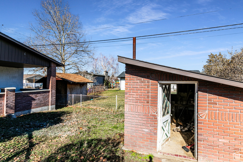 View of yard featuring an outdoor structure and fence