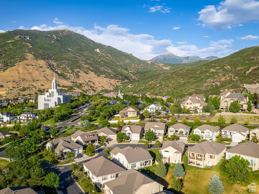 Aerial view of property and surrounding area featuring nearby suburban area and mountains