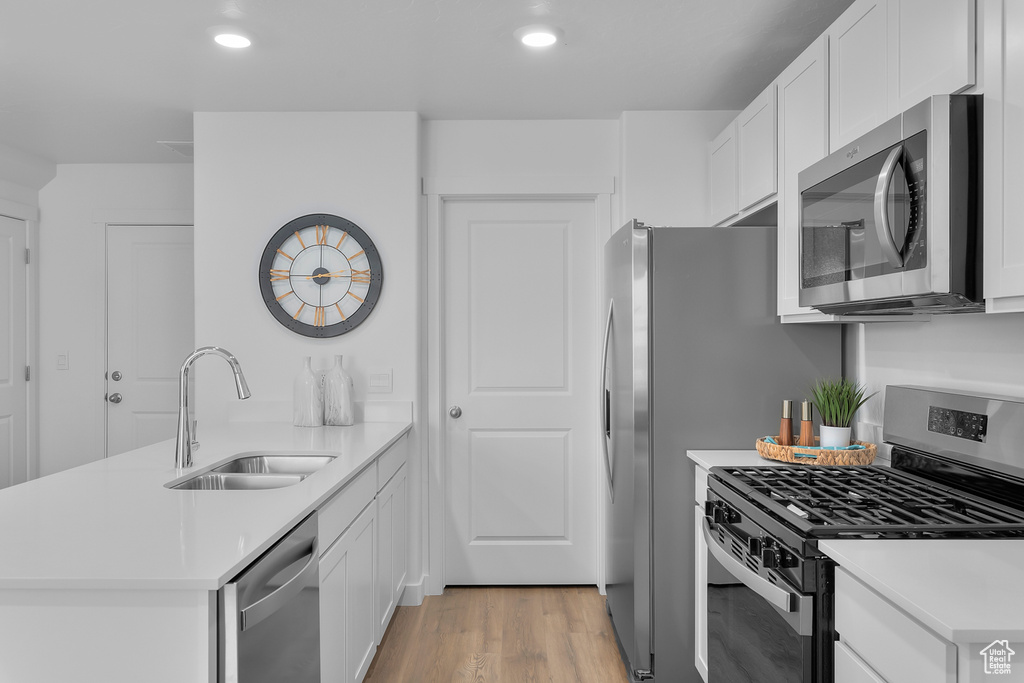 Kitchen with light countertops, a peninsula, a sink, and stainless steel appliances